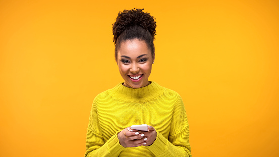 Excited Afro-American lady smiling on camera phone hand, social network message