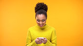 Smiling African-American woman chatting on smartphone, modern technology, app