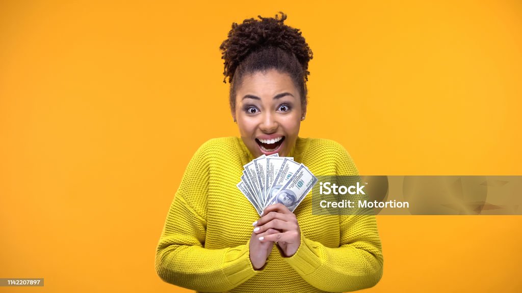 Excited Afro-American woman holding bunch of dollars, lottery winner, fortune Currency Stock Photo