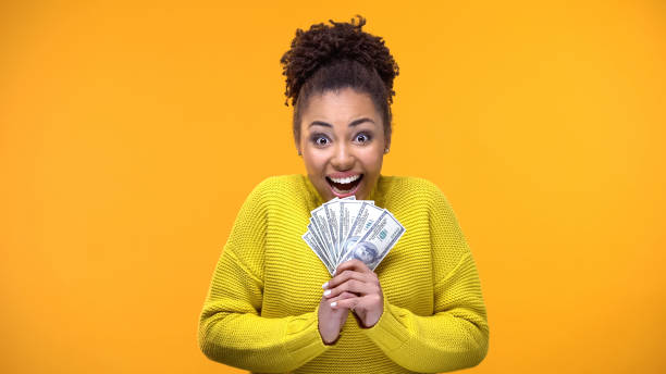 excited afro-american woman holding bunch of dollars, lottery winner, fortune - us paper currency fotos imagens e fotografias de stock