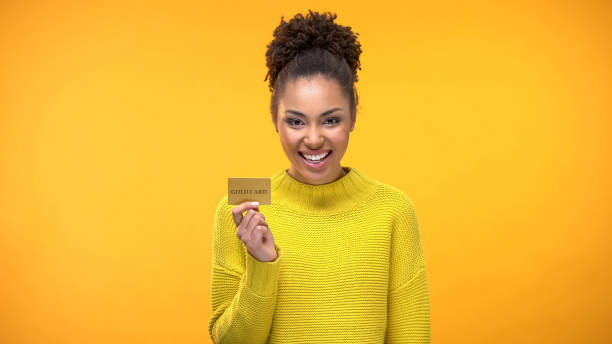 mujer negra con tarjeta de crédito dorada, programas de banca vip para gente rica - greeting card holding women credit card fotografías e imágenes de stock