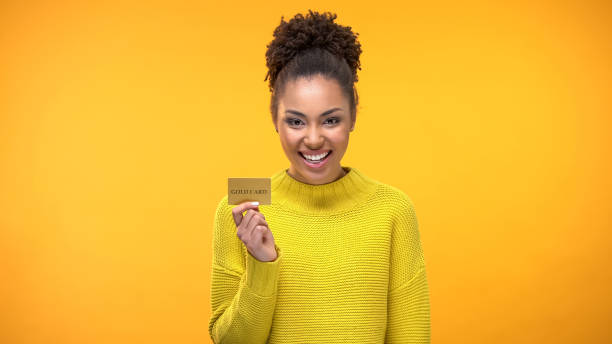 Black woman holding golden credit card, VIP banking programs for rich people Black woman holding golden credit card, VIP banking programs for rich people Holding stock pictures, royalty-free photos & images