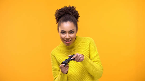 istock Young african-american woman playing video games with game controller, fun 1142209495