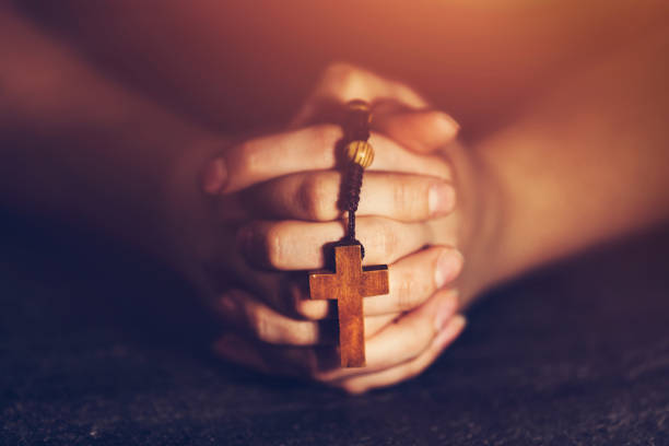mujer sosteniendo un rosario y rezando. - praying human hand worshipper wood fotografías e imágenes de stock