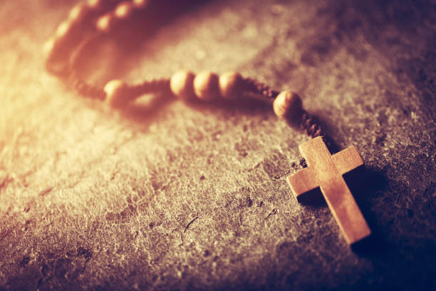 Wooden rosary with cross on stone background. Christian religion. Catholic faith. Prayer.
