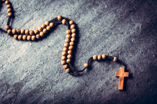 istock Wooden rosary laying on stone background. 1142214323