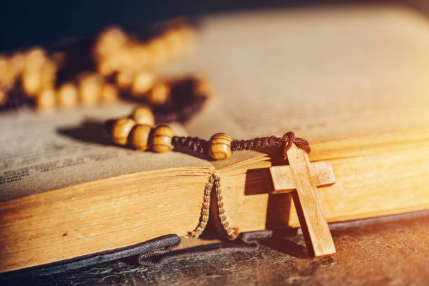 istock Rosary with cross laying on a Bible book. 1142214326