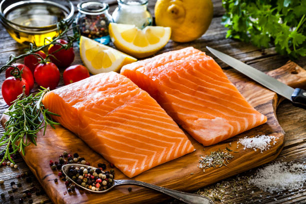 istock Two raw salmon fillets ready for cooking shot on rustic kitchen table 1142214616