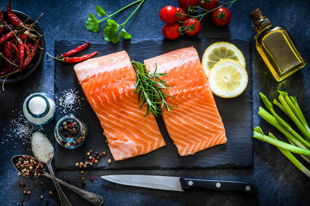 istock Two raw salmon fillets ready for cooking shot on dark kitchen table 1142214649