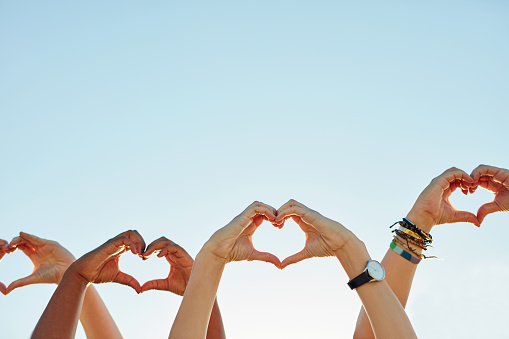 Cropped shot of a group of people forming a heart shape with their hands