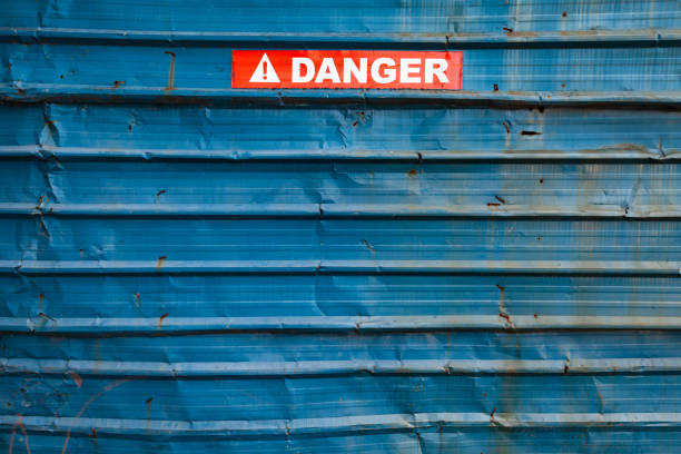 опасный знак над шероховатый синий �металлической стены - sign rust old fashioned corrugated iron стоковые фото и изображения