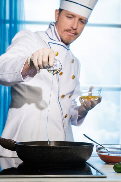 istock Cook pours vegetable oil into the pan 1142219715