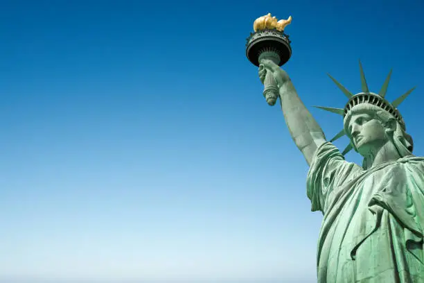 Photo of Close up of the Statue of Liberty in New York, USA. Blue sky background with copy space