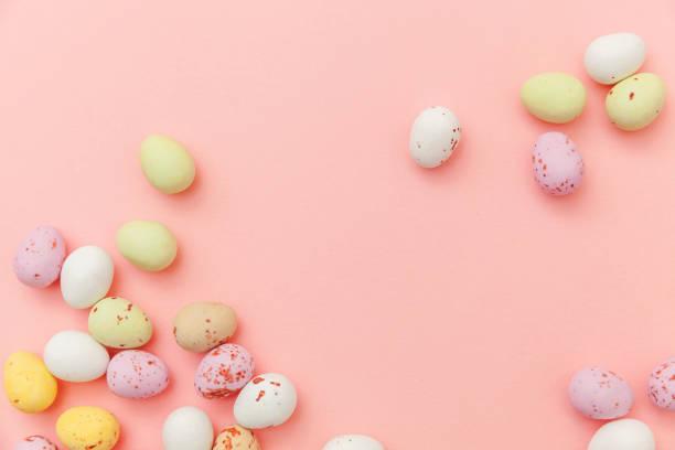 istock Happy Easter concept. Easter candy chocolate eggs and jellybean sweets isolated on trendy pastel pink background. Simple minimalism flat lay top view copy space 1142222591