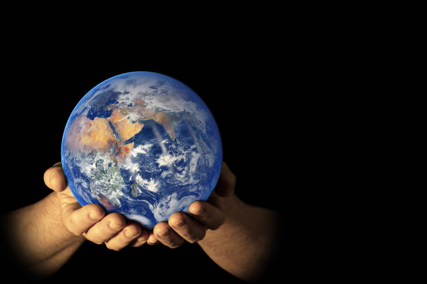 Earth (East view) in male hands isolated on a black background. Space for copy. Earth globe image provided by NASA - https://earthobservatory.nasa.gov/images/84214/blue-marble-eastern-hemisphere
