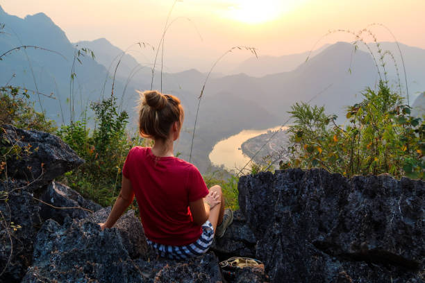 femme regardant la vue charmante de la colline - hiking young women outdoors t shirt photos et images de collection