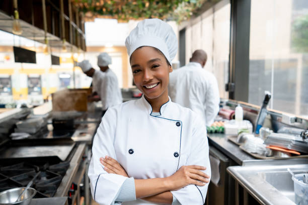 Beautiful chef working in a kitchen at a restaurant Portrait of a beautiful female chef working in a kitchen at a restaurant and looking at the camera smiling â gastronomy concepts chef stock pictures, royalty-free photos & images