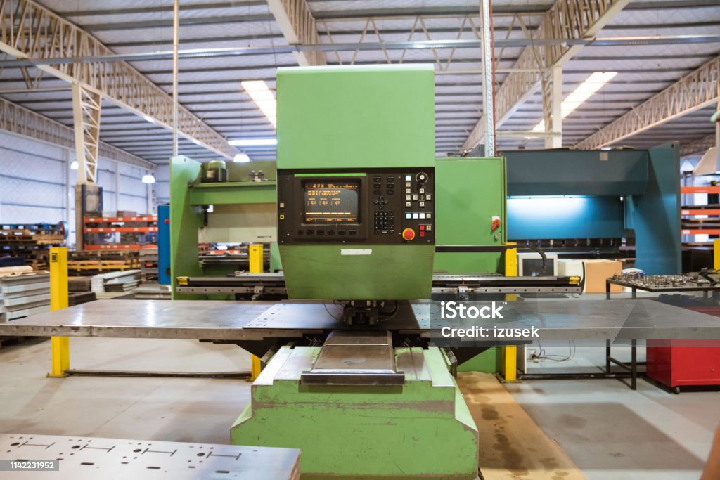 Manufacturing machinery in factory Green puller machine in industry. Manufacturing machinery in factory. Absence Stock Photo