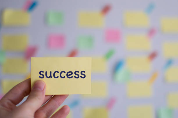 istock A hand holding success sticky note in front of a kanban board 1142232897