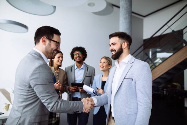 istock Businessmen shaking hands in the office hallway 1142233034