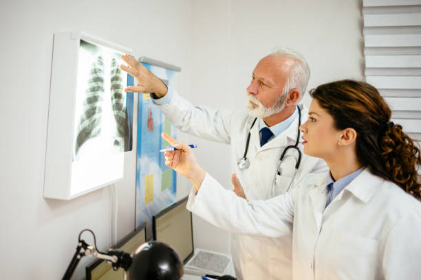 los médicos masculinos y femeninos que discuten la imagen de rayos x - x ray image radiologist examining using voice fotografías e imágenes de stock
