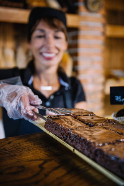 istock Female Shop Assistant Selling Chocolate Cake In Bakery 1142235852