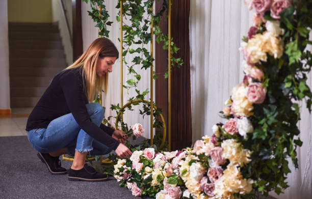 Woman arranging flowers and decorations for wedding celebration