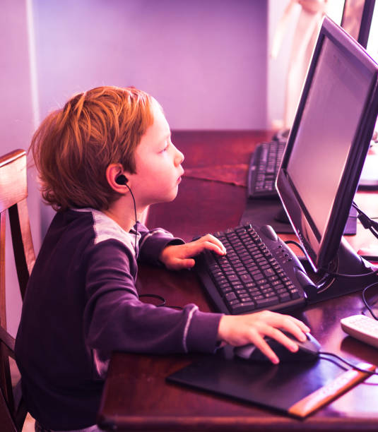 istock Cute little boy playing at pc concentrated 1142238611