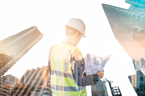 istock Double exposure of engineering holding blueprint in his hand, Engineers examine the blueprints on city and skyscraper background , Engineering concept. 1142238676