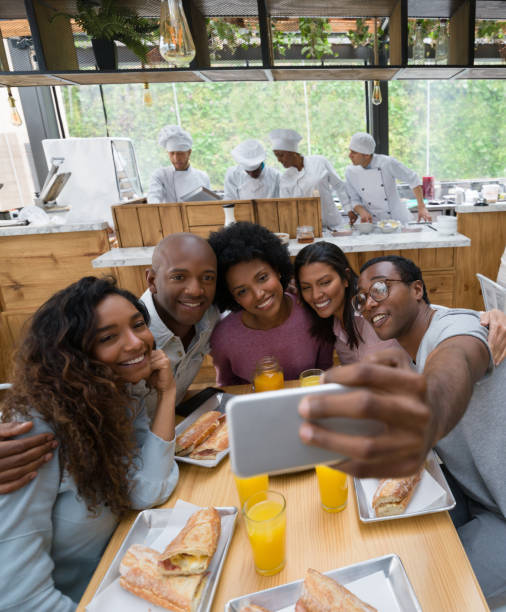 istock Happy group of friends taking a selfie at a restaurant 1142243776