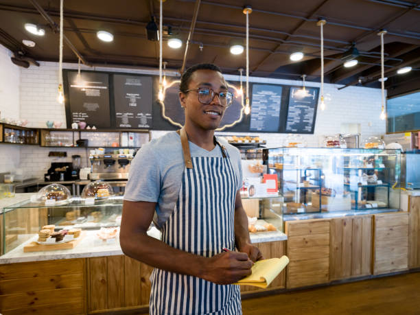 istock Happy waiter working at a restaurant holding a notepad and smiling 1142243802
