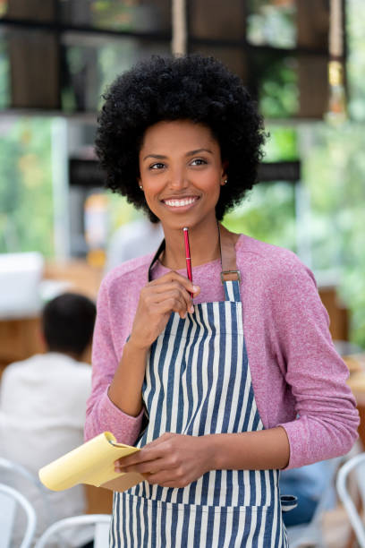 istock Thoughtful African American waitress working at a restaurant and smiling 1142243836