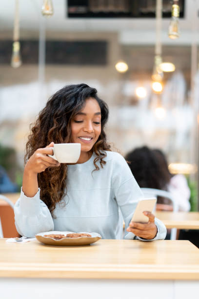 istock Beautiful woman texting on her cell phone at a cafe 1142243858