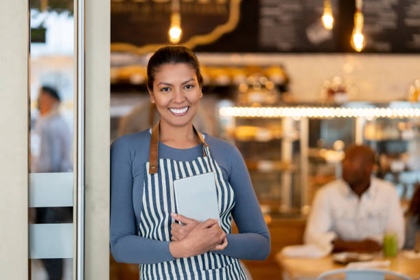 istock Beautiful waitress working at a restaurant and looking very happy 1142243880