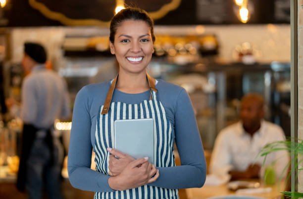 istock Friendly waitress working at a restaurant and smiling 1142243888