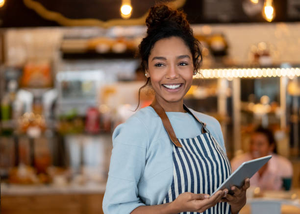 Beautiful waitress working at a restaurant using a tablet computer Portrait of a beautiful waitress working at a restaurant using a tablet computer and smiling waitress stock pictures, royalty-free photos & images