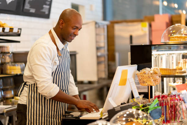istock Happy waiter working the cashier at a cafe 1142243924