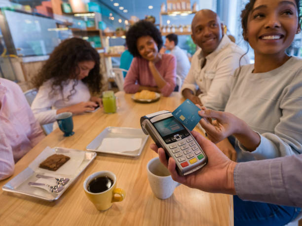 istock Happy customers paying at a restaurant with a credit card 1142243943