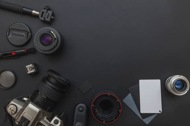istock Photographer workplace with dslr camera system, camera cleaning kit, lens and camera accessory on dark black table background 1142244058