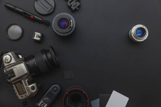 istock Photographer workplace with dslr camera system, camera cleaning kit, lens and camera accessory on dark black table background 1142244078