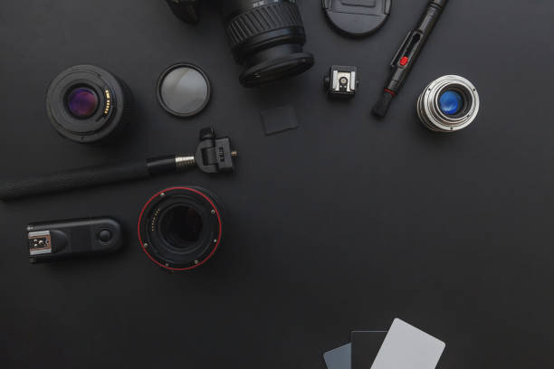 istock Photographer workplace with dslr camera system, camera cleaning kit, lens and camera accessory on dark black table background 1142244101
