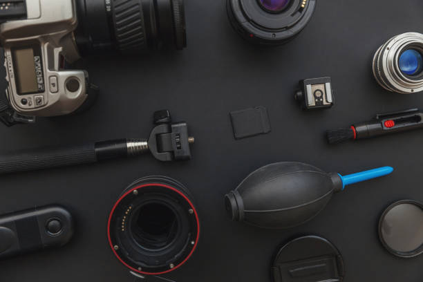 istock Photographer workplace with dslr camera system, camera cleaning kit, lens and camera accessory on dark black table background 1142244119