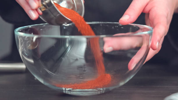 istock Mixing together spice rub in glass mixing bowl. 1142250473