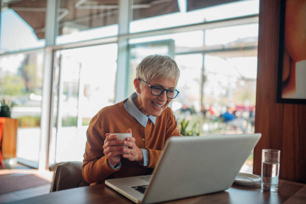 istock Woman holding a cup of coffee when using laptop 1142253752