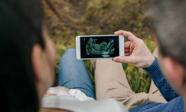istock Pregnant looking ultrasound on the mobile with her husband 1142259085