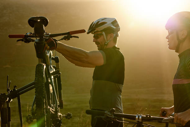Preparing for an epic bike ride Shot of a man and woman riding their bicycles in the countryside bicycle rack photos stock pictures, royalty-free photos & images