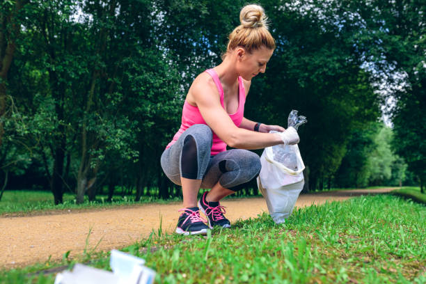 istock Girl picking up trash doing plogging 1142263084