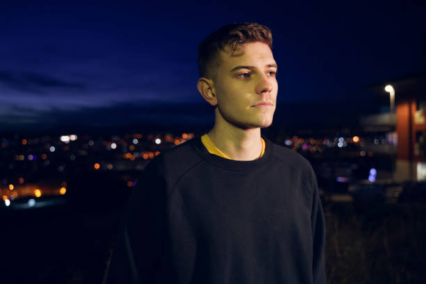 istock Thoughtful young man by city lights 1142264259