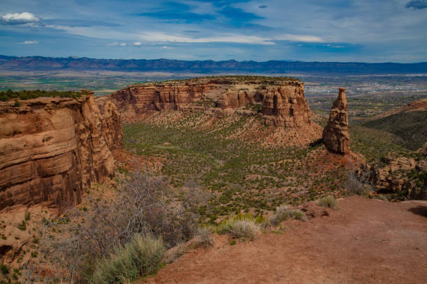 Grand View of the Colorado National Monument's Independence Rock overlooking the Grand Valley in Western Colorado at night with Fruita city lights and vibrant stars in the sky