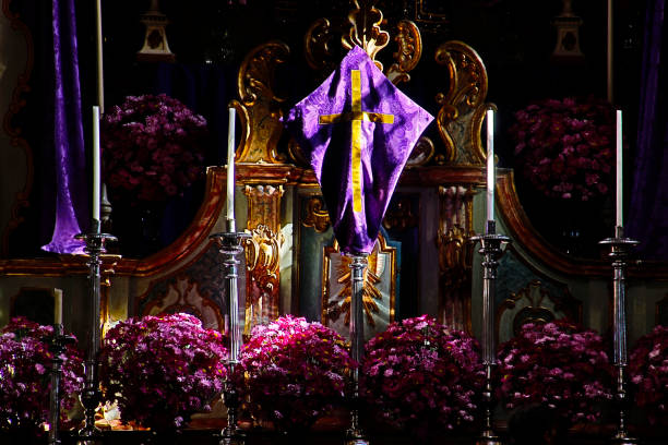 This photo captures the serene altar of Saint Thomas Church in Strasbourg, Alsace, France. The altar is adorned with symbolic elements, including a crucifix, an open Bible, and fresh flowers in a vase. Behind the altar, the high vaulted Gothic arches frame a modern cross installation, adding a contemporary touch to the historic setting. The stained glass windows and ornate chandeliers enhance the sacred atmosphere, reflecting the spiritual and architectural heritage of this iconic Protestant church.